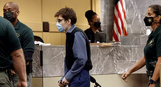 Marjory Stoneman Douglas High School shooter Nikolas Cruz crosses the courtroom in handcuffs at the Broward County Courthouse after being sentenced on four criminal counts stemming from his attack on a Broward County jail guard in November 2018, on October 20, 2021 in Fort Lauderdale, Florida. Amy Beth Bennett-Pool/Getty Images/AFP